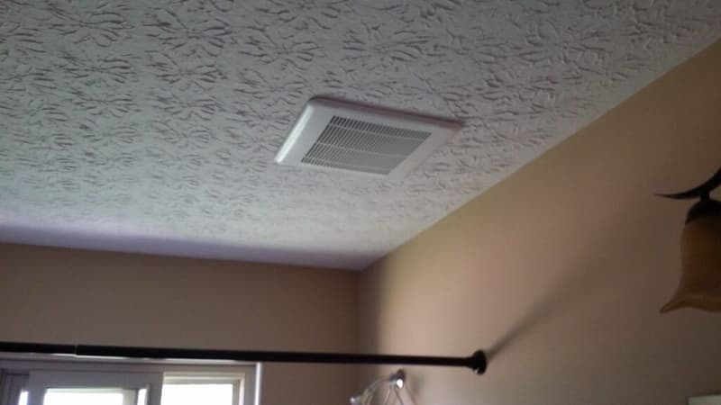 Bathroom exhaust fan installed in textured ceiling
